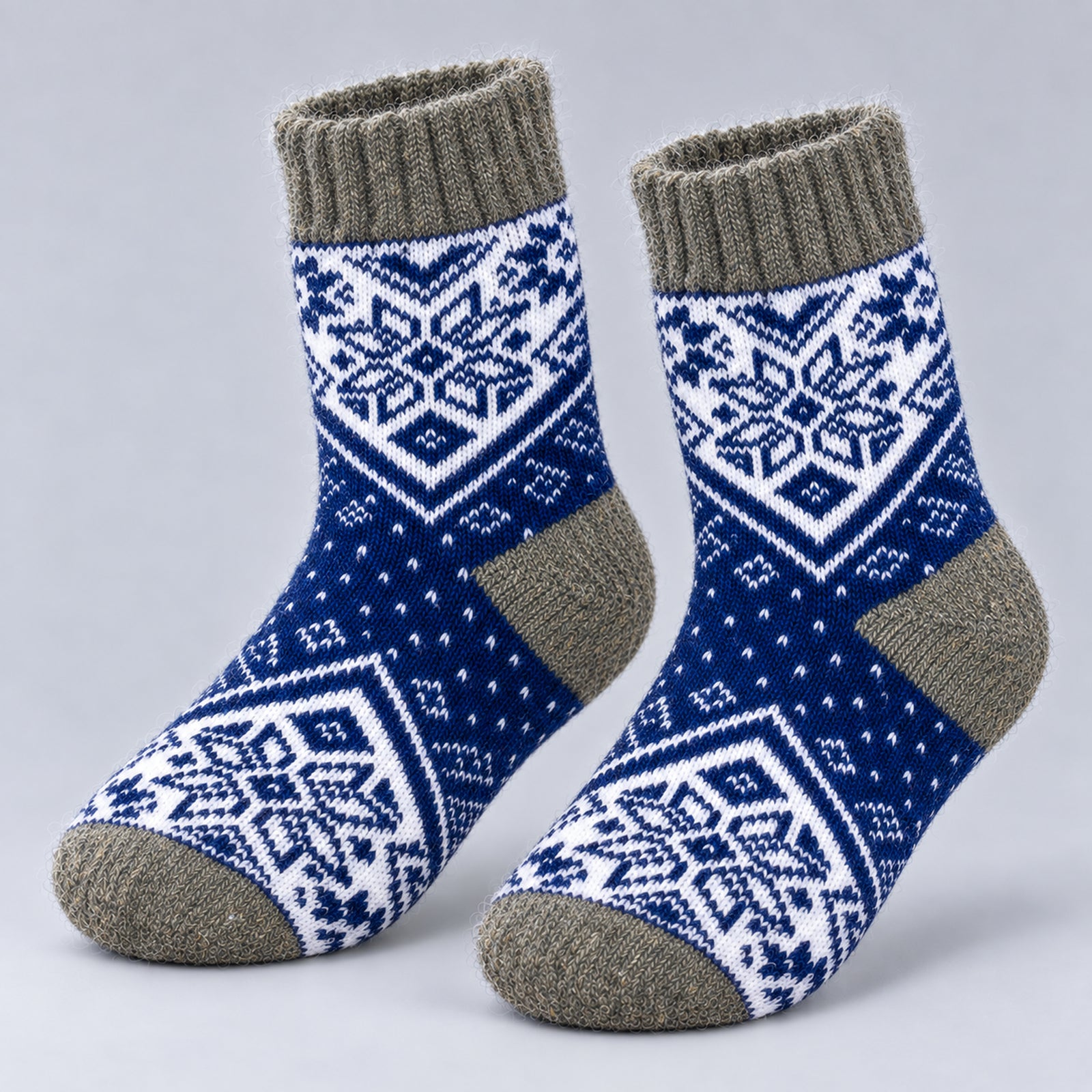 A pair of knit ankle socks with a blue and white Nordic snowflake pattern and solid gray ribbed cuffs, heels, and toes, displayed on a light gray background.