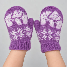 A pair of purple knit mittens with white snowflake and animal motifs, worn on hands against a light gray background.