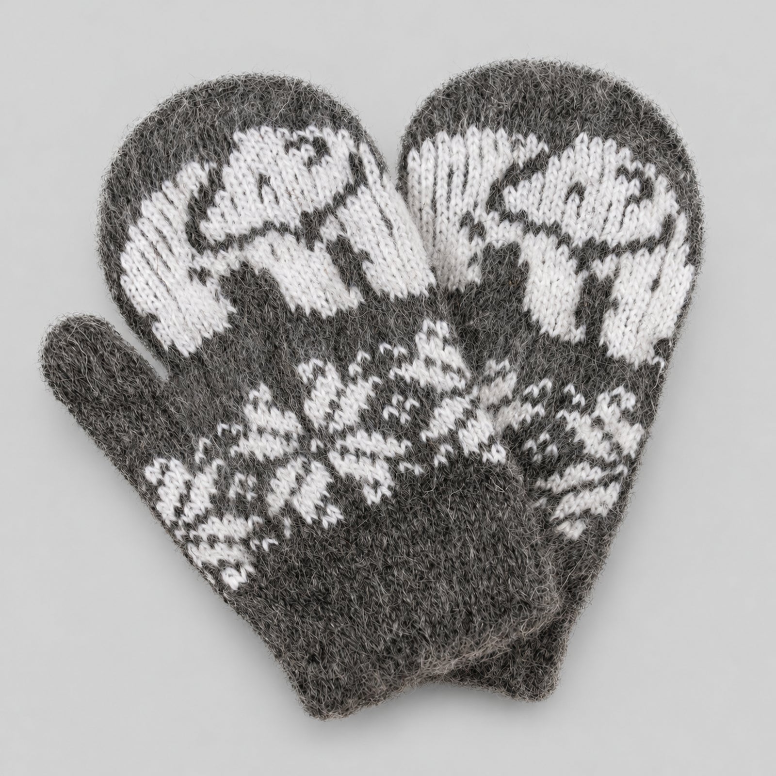 A pair of knit mittens in heather gray and white, featuring a polar bear pattern on the back of the hands and a snowflake design on the palms, displayed on a neutral gray background.