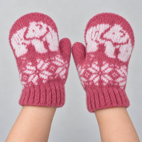 A pair of pink and white hand-knit mittens with a polar bear and snowflake pattern, shown on a person's hands against a light gray background.