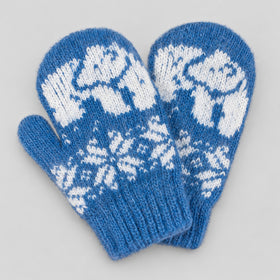 A pair of blue knit mittens with white fair isle patterns featuring polar bears and snowflakes, displayed on a neutral light gray background.