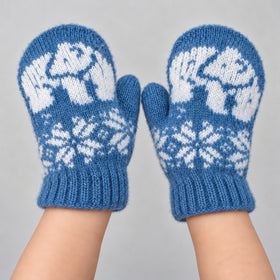 A pair of blue knit mittens with white Nordic-style patterns, worn on hands against a light gray background.