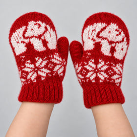 A pair of red knit mittens with white Nordic-style patterns, worn on hands against a light gray background.
