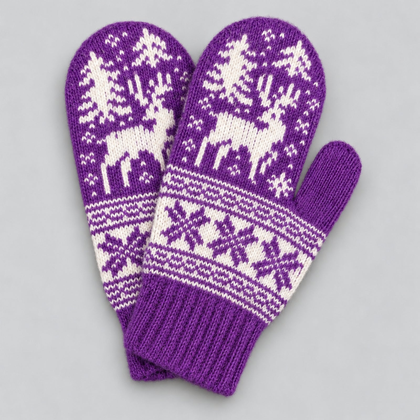 A pair of purple knit winter mittens with white Nordic-style patterns featuring reindeer, trees, and snowflakes, displayed on a neutral gray background.