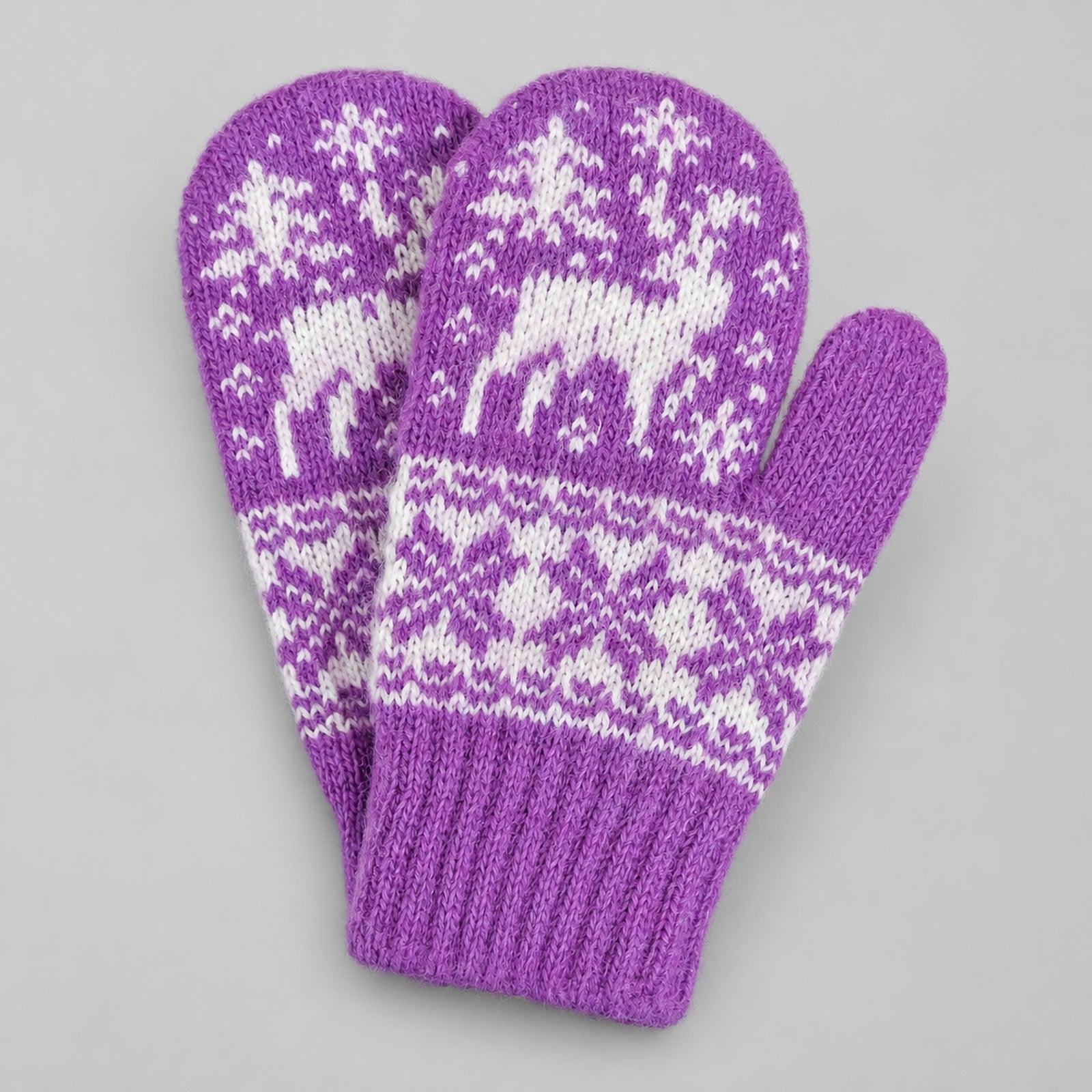 A pair of purple and white knit winter mittens featuring a white reindeer and snowflake pattern on a solid purple background, displayed on a neutral gray background.