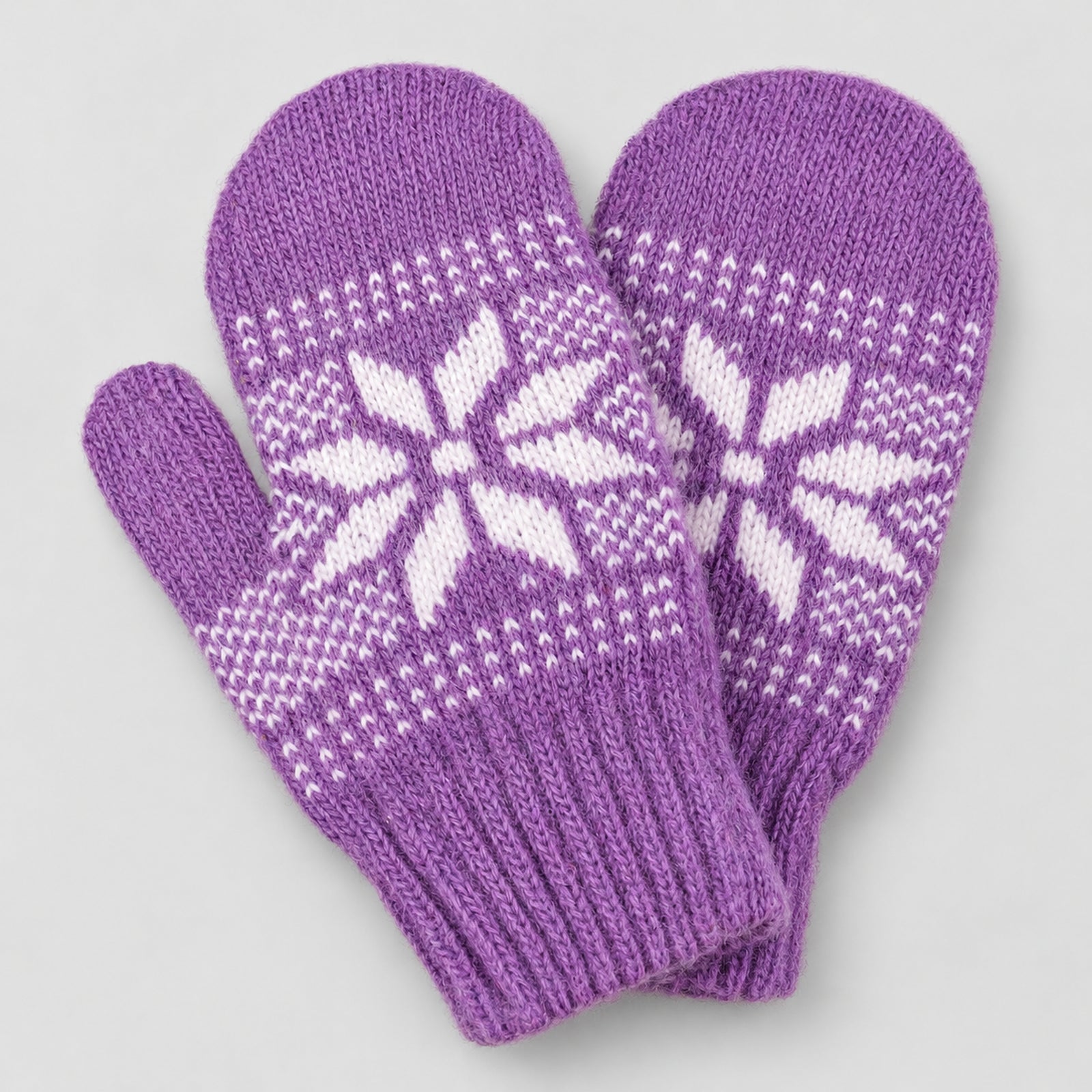 A pair of purple knit mittens with white Nordic snowflake patterns, displayed on a light gray background.