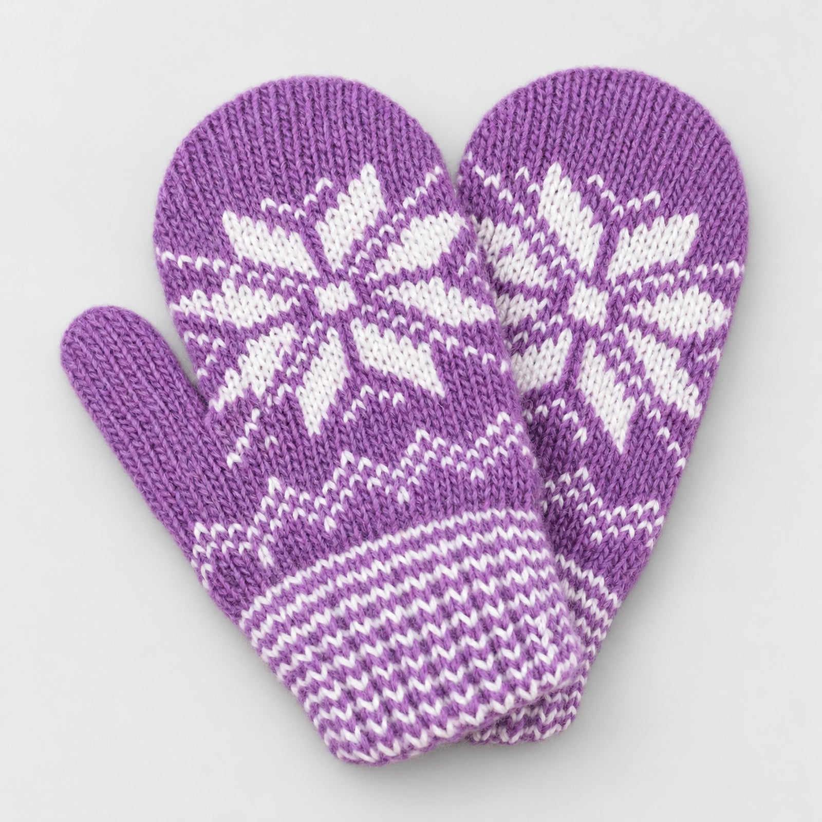 A pair of purple knit mittens with white Nordic snowflake and geometric patterns, displayed on a light gray background.