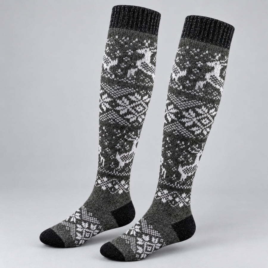 A pair of knee-high knit socks with a gray and white Nordic/Fair Isle pattern featuring reindeer and snowflakes, shown on a light gray background.