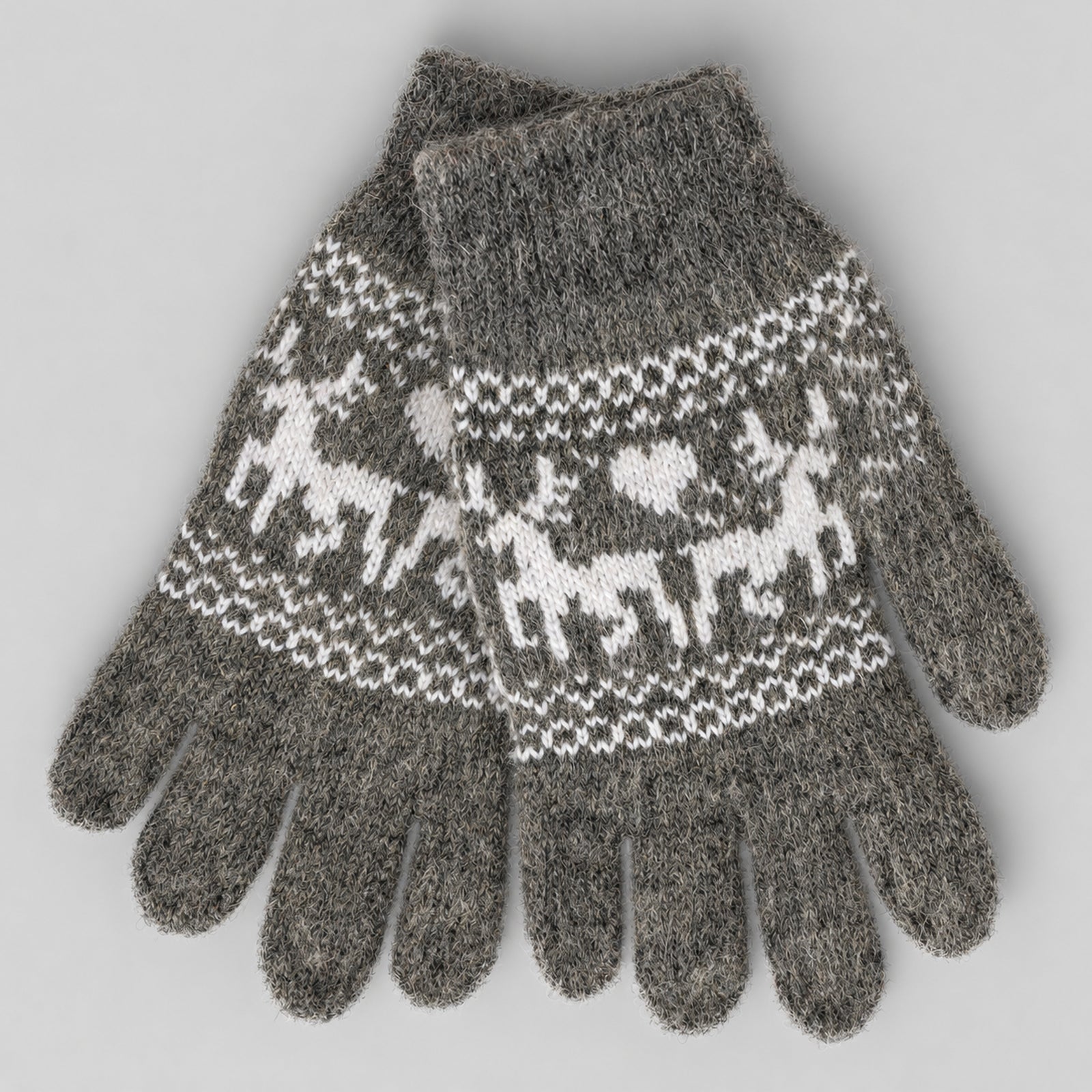 A pair of heather gray knit gloves featuring a white Fair Isle pattern of reindeer and geometric motifs across the back of the hands, displayed on a neutral gray background.