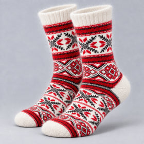 A pair of crew socks with a red, black, and white Nordic/Fair Isle pattern, displayed on a neutral gray background.