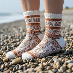 Person wearing patterned socks on a pebbly beach