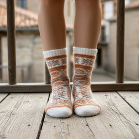 Person wearing patterned socks on a wooden balcony with buildings in the background