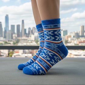 Person wearing blue patterned socks with a city skyline in the background