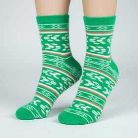 Green patterned socks worn by a person on a white background