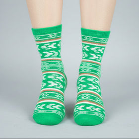 Green patterned socks worn by a person on a gray background