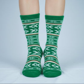 Green patterned socks worn by a person on a gray background