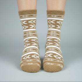 Pair of brown and white patterned socks on a neutral background