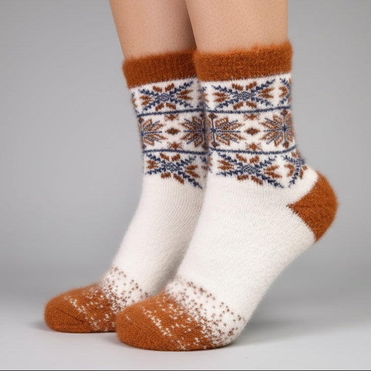 White and brown patterned sock on a mannequin foot against a light grey background