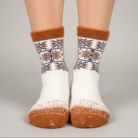 White and brown patterned sock on a mannequin foot against a light grey background