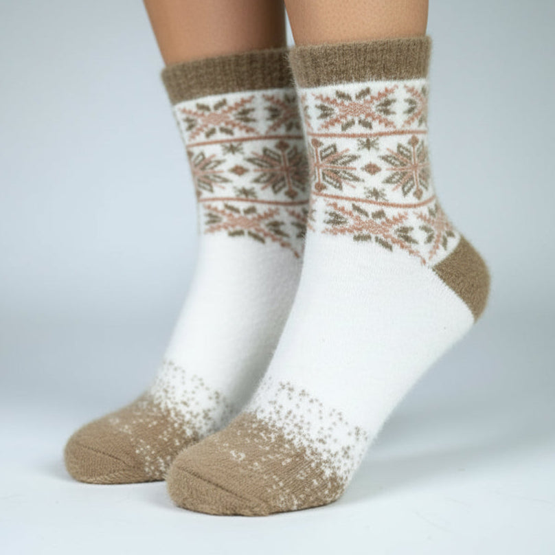 Pair of white socks with brown pattern worn on a plain background
