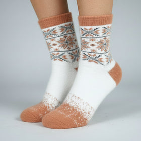 White socks with brown and patterned design worn by a person on a gray background