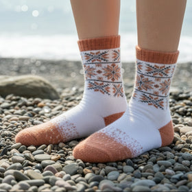Person wearing patterned socks on a gray stool with a dark background