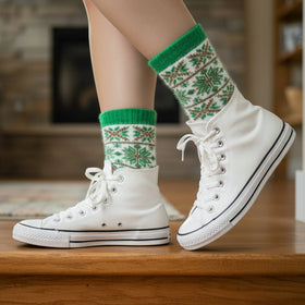 White sneakers with green patterned socks on a wooden floor.