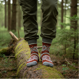 Person standing on a log in a forest wearing patterned socks.