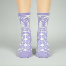 Purple socks with white patterns worn by a person on a gray background