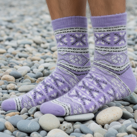 Purple patterned socks on a person standing on pebbles