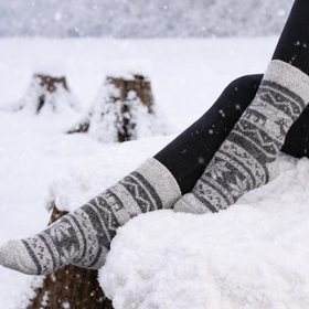 Person wearing patterned socks sitting in the snow