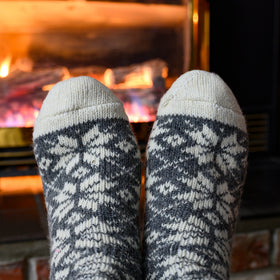 Pair of patterned socks in front of a fireplace