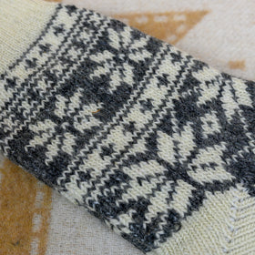 Close-up of a knitted fabric with a houndstooth pattern on a textured surface.