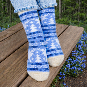 Blue and white patterned socks worn by a person sitting on a wooden bench with a natural background.