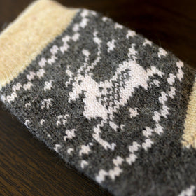 Gray sock with white pattern on a wooden surface