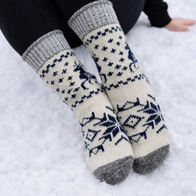 Pair of patterned socks with gray cuffs and toes, worn in the snow.