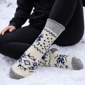 Person wearing patterned socks sitting in the snow