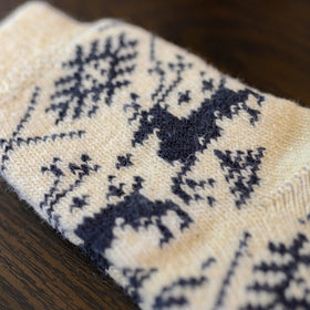 Knitted sock with blue pattern on a wooden surface