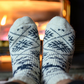White socks with blue patterns worn indoors, blurred background
