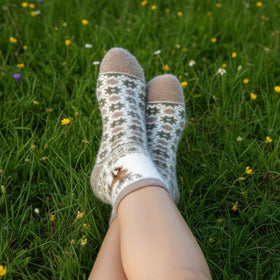 Person wearing patterned socks on a grassy field with wildflowers