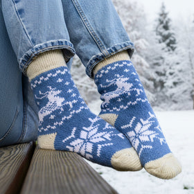 Blue and white patterned socks worn outdoors on a wooden bench.