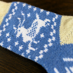 Close-up of a blue fabric with white pattern, possibly a sock or towel.