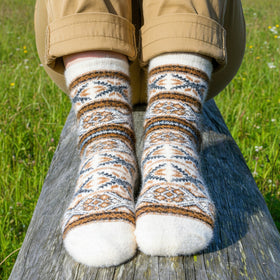 Person wearing patterned socks sitting on a log with a natural background