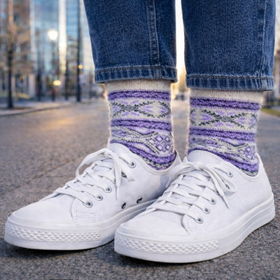 White sneakers with patterned purple socks on a city street.