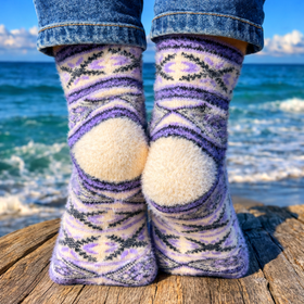 Person wearing patterned socks with a blue sky and ocean background