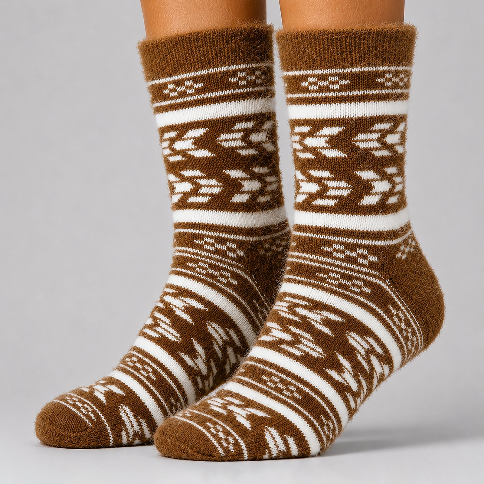 A pair of brown and off-white patterned crew socks worn on feet, shown against a neutral gray studio background.