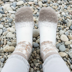 White socks with brown accents on a pebble ground