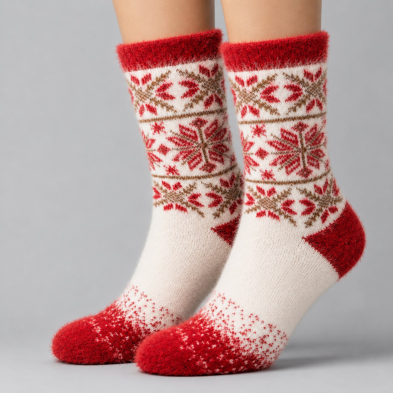 A pair of crew socks with a festive Fair Isle pattern in red, cream, and brown, shown on a model's feet against a neutral gray background.