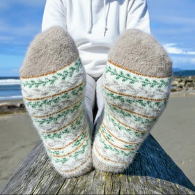 Person wearing patterned socks with a beach background