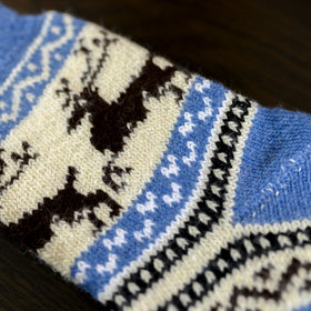 Close-up of a knitted fabric with blue, black, and white pattern